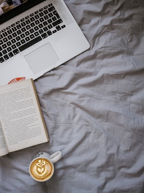 A cozy workspace with books, a laptop, and coffee, symbolizing literary marketing.