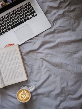 A warm, inviting workspace with books, a laptop, and a steaming cup of coffee ready to assist authors.