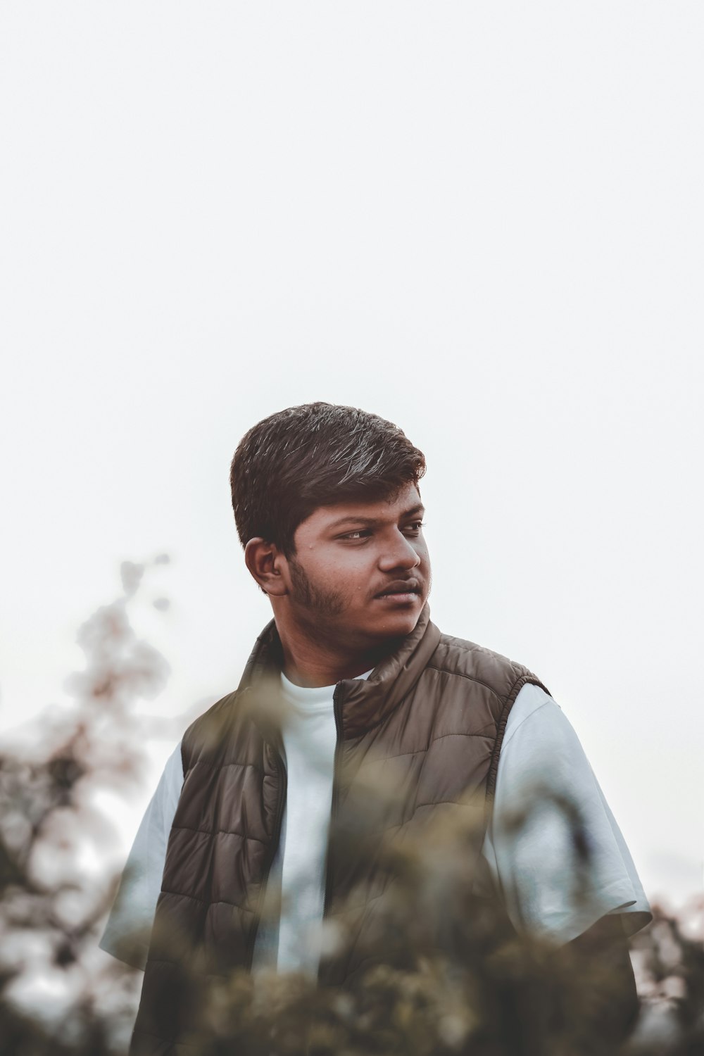 man in brown bubble vest and white shirt