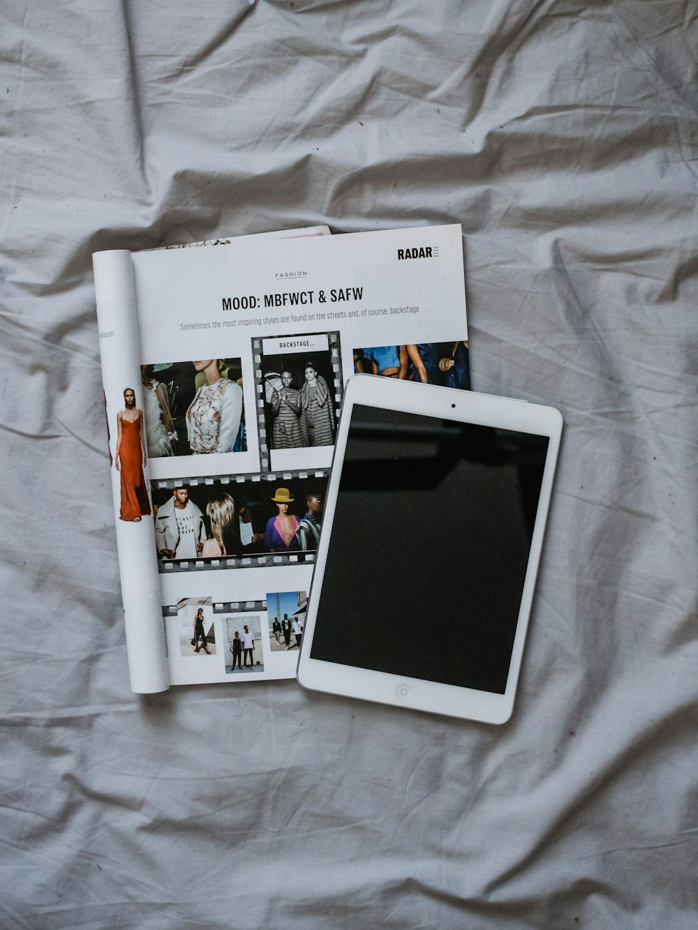 iPad branco e livro sobre têxteis