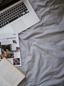 A cozy reading corner with magazines and a laptop showing the Aoeron magazine articles.
