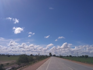 A freshly paved highway stretching through Punjab's countryside under a clear blue sky.
