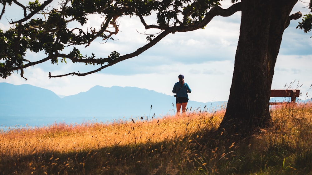 man standing on the cliff watching the mountain