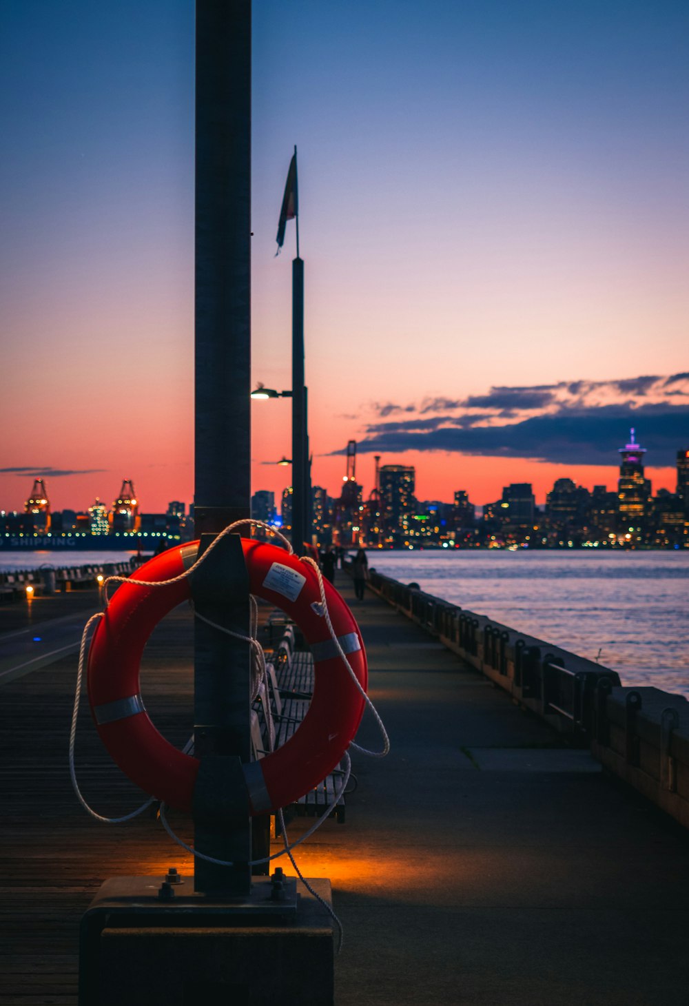 red life ring mounted on pole at the harbor