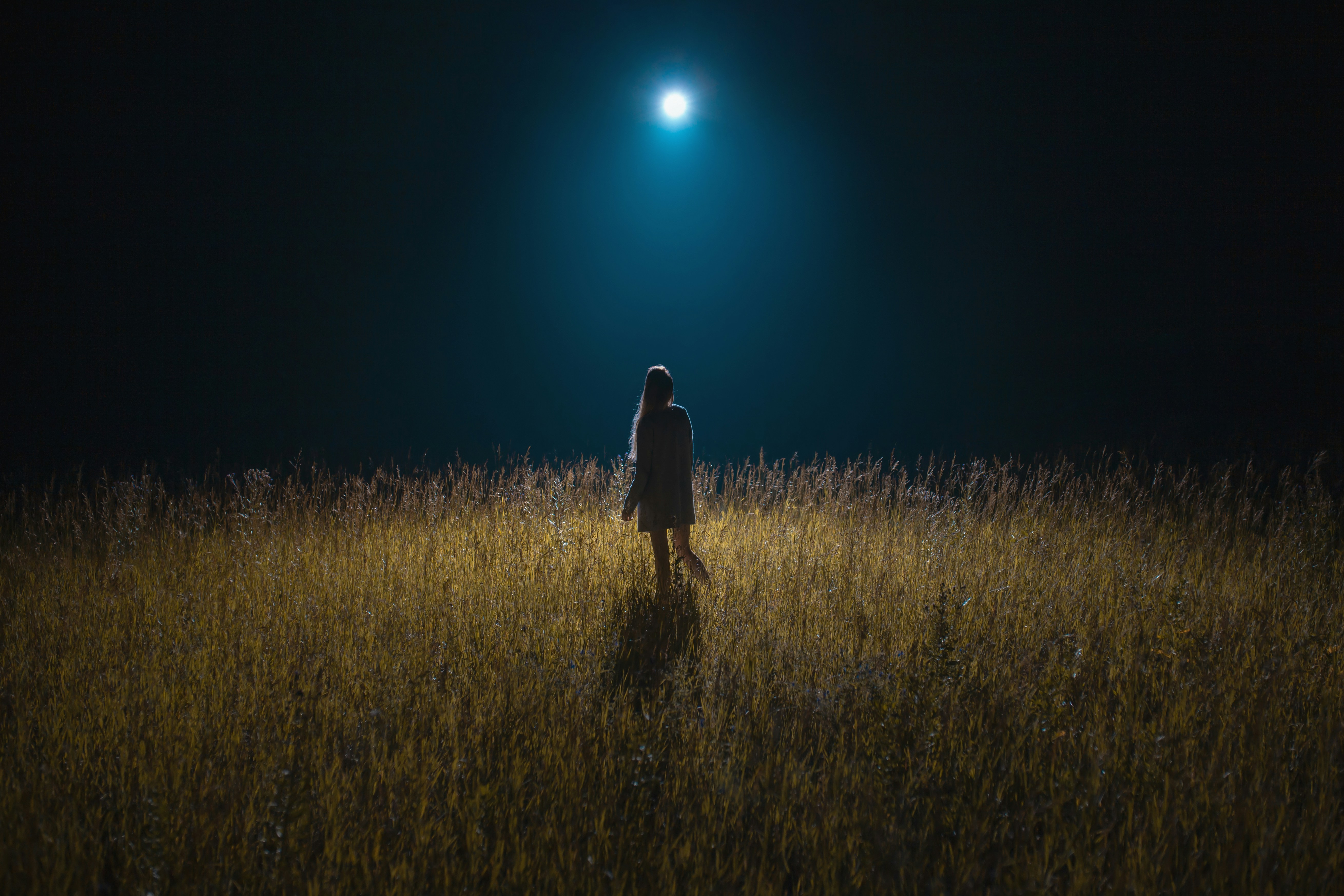 A person standing in a dark field