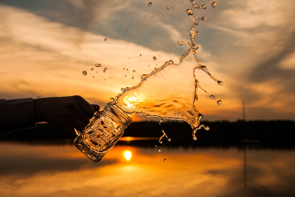 water pouring out from clear glass jar