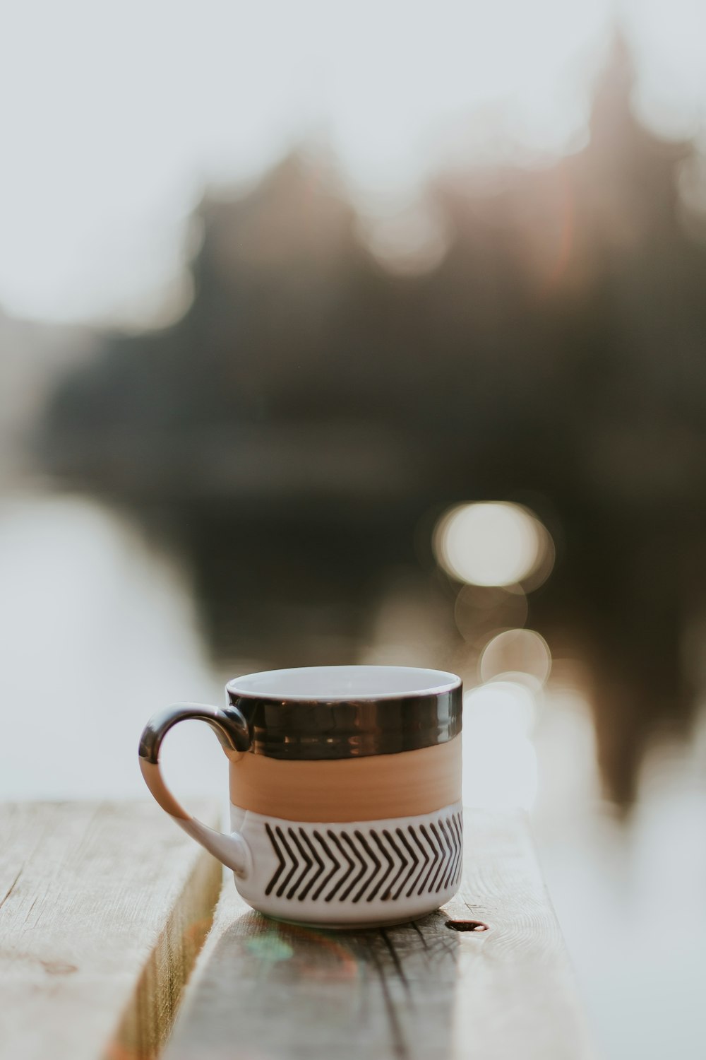 white, brown, and black ceramic mug