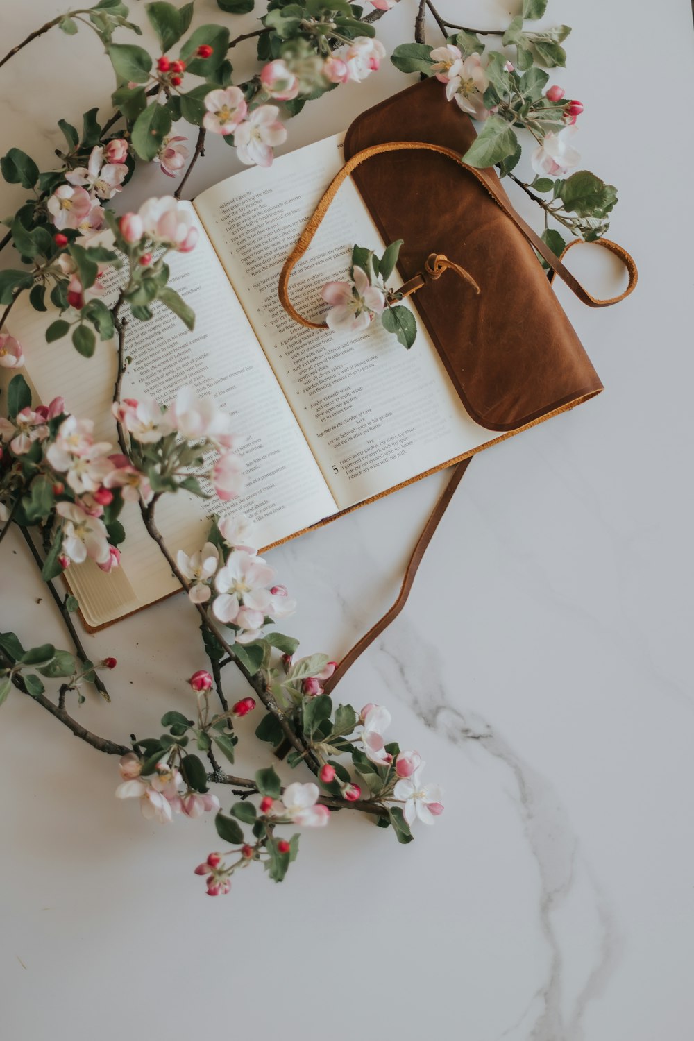 opened white book with pink and green floral ornament