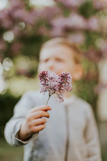 Quiet moment captured of a child holding a bouquet of wildflowers, painted with dusty blue and antique gold accents