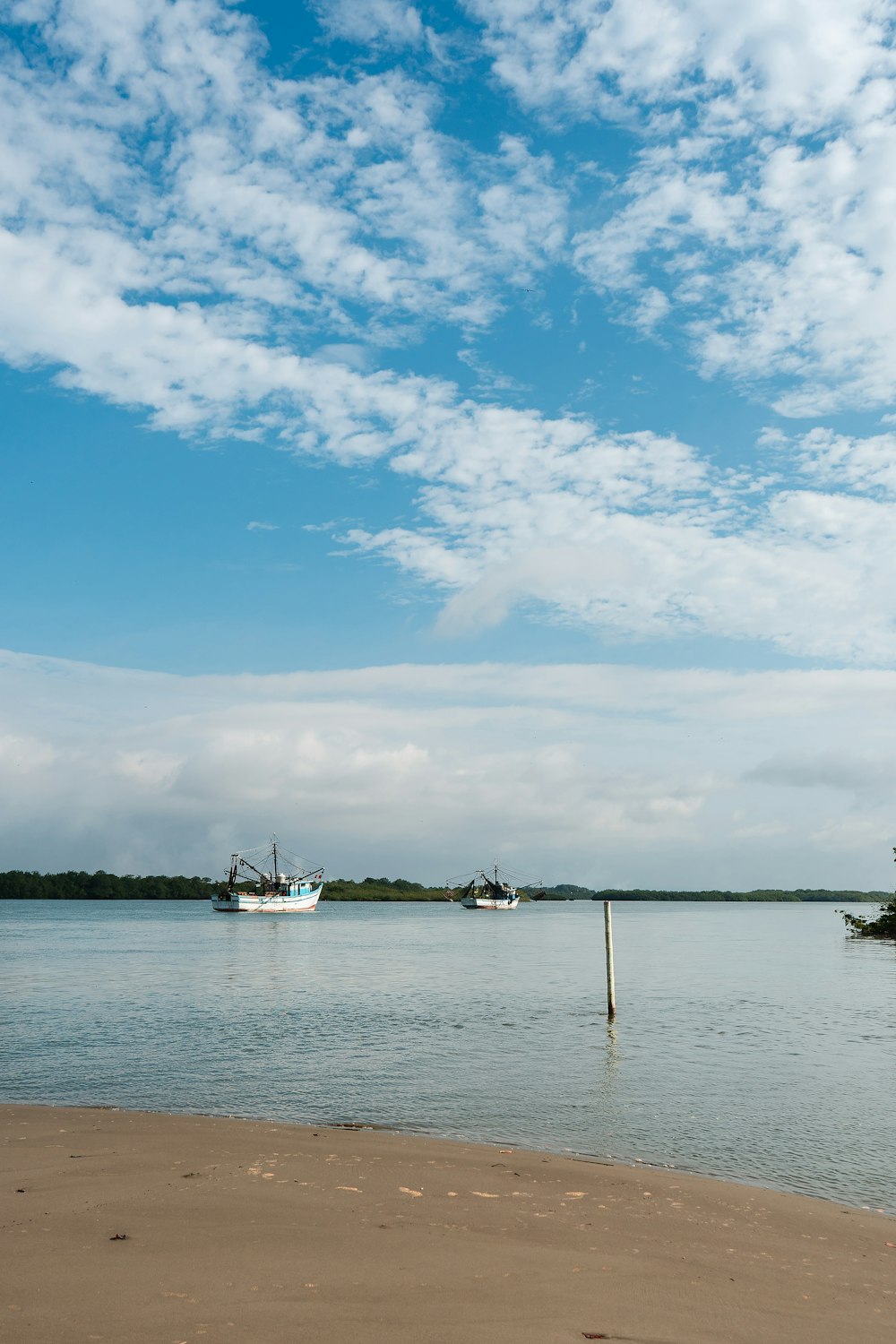 body of water under blue and white sky at daytime