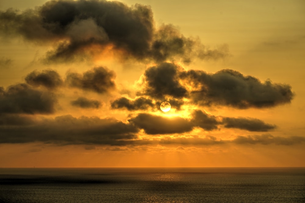 the sun is shining through the clouds over the ocean