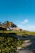 A serene beachfront bungalow surrounded by tall coconut trees under a clear blue sky at sunset.