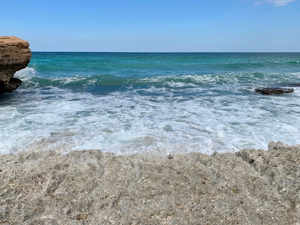 Spruzzi d'onda del mare sulla formazione rocciosa