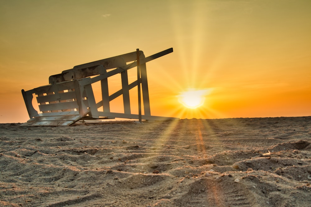 white wooden bench on sand