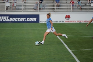 A dynamic shot of a female soccer player mid-kick, stadium lights glowing behind her.
