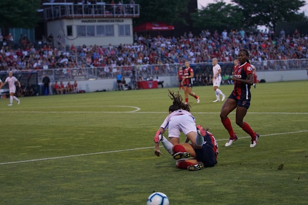 A vibrant women's soccer match in a sunny Barcelona field with enthusiastic players.