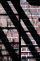 A partially built brick wall with sunlight casting shadows.