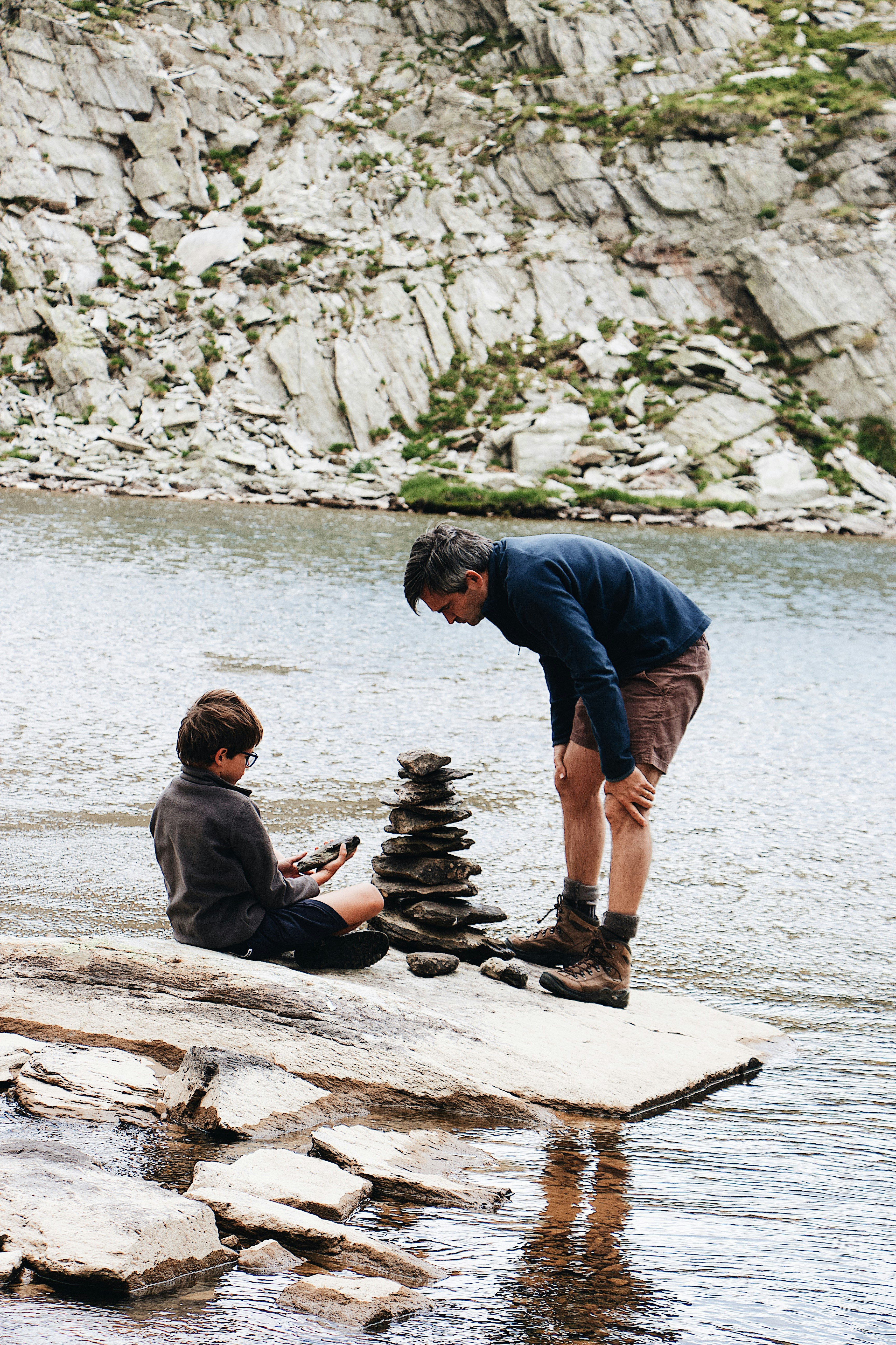 boy and man beside river during daytime