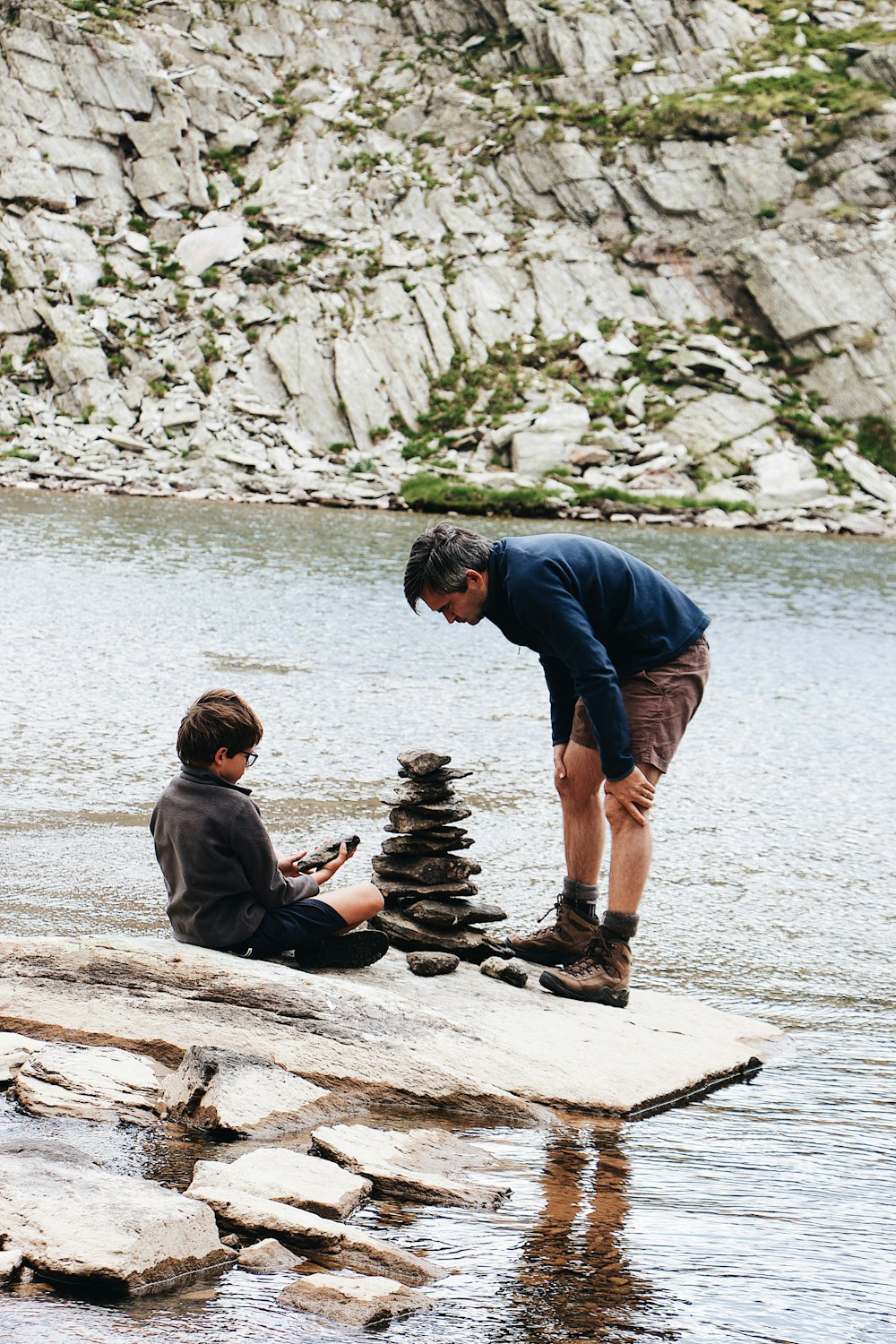 boy and man beside river during daytime