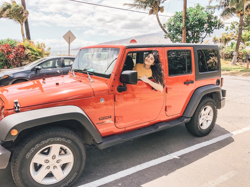 woman riding on red and black vehicle during daytime