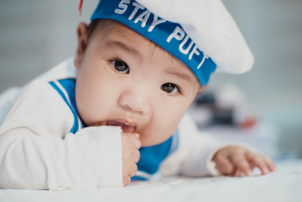 흰색과 파란색 네이비 의상을 입은 아기