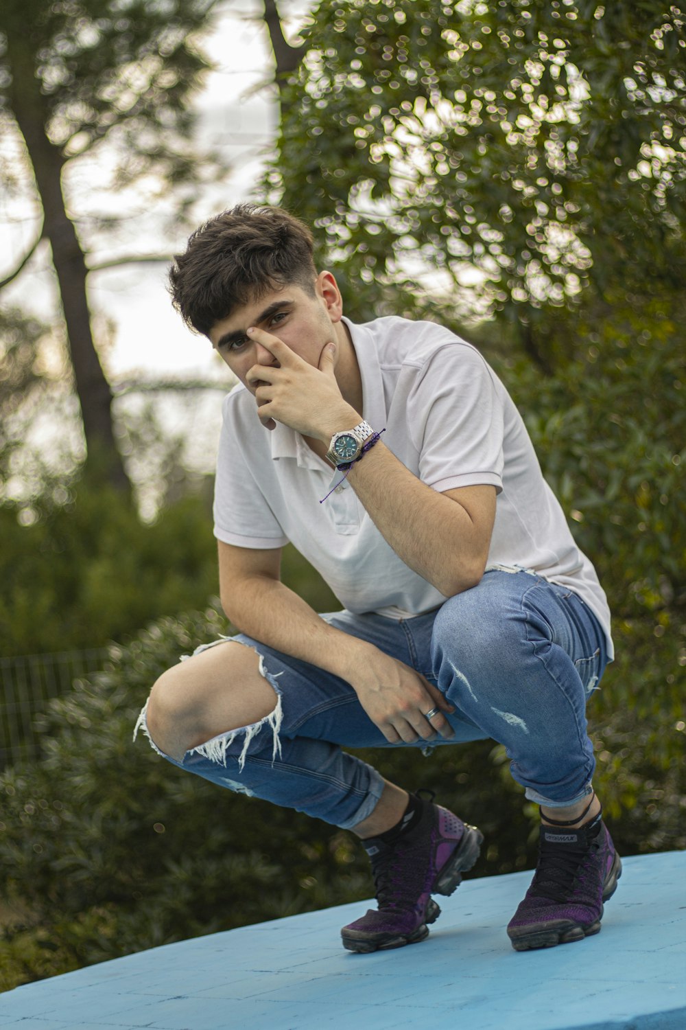 a man sitting on top of a blue bench