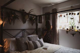 Cozy vintage-style bedroom with soft natural light and floral decorations.