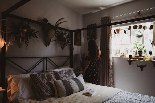 Cozy vintage-style bedroom with soft natural light and floral decorations.