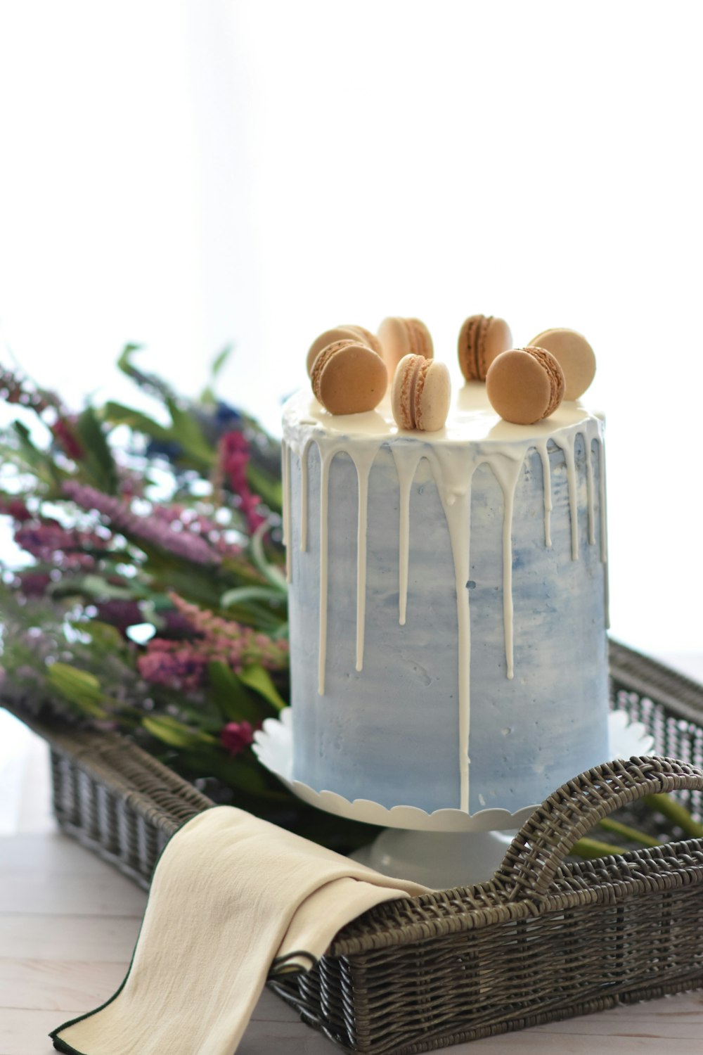 round white icing-covered cake with macaron's on top