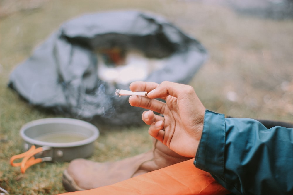 person holding white cigarette stick