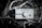 A silver headphone amplifier labeled 'ERZETICH' rests among twisted branches, featuring a central knob with decorative devil horns and various input/output ports.