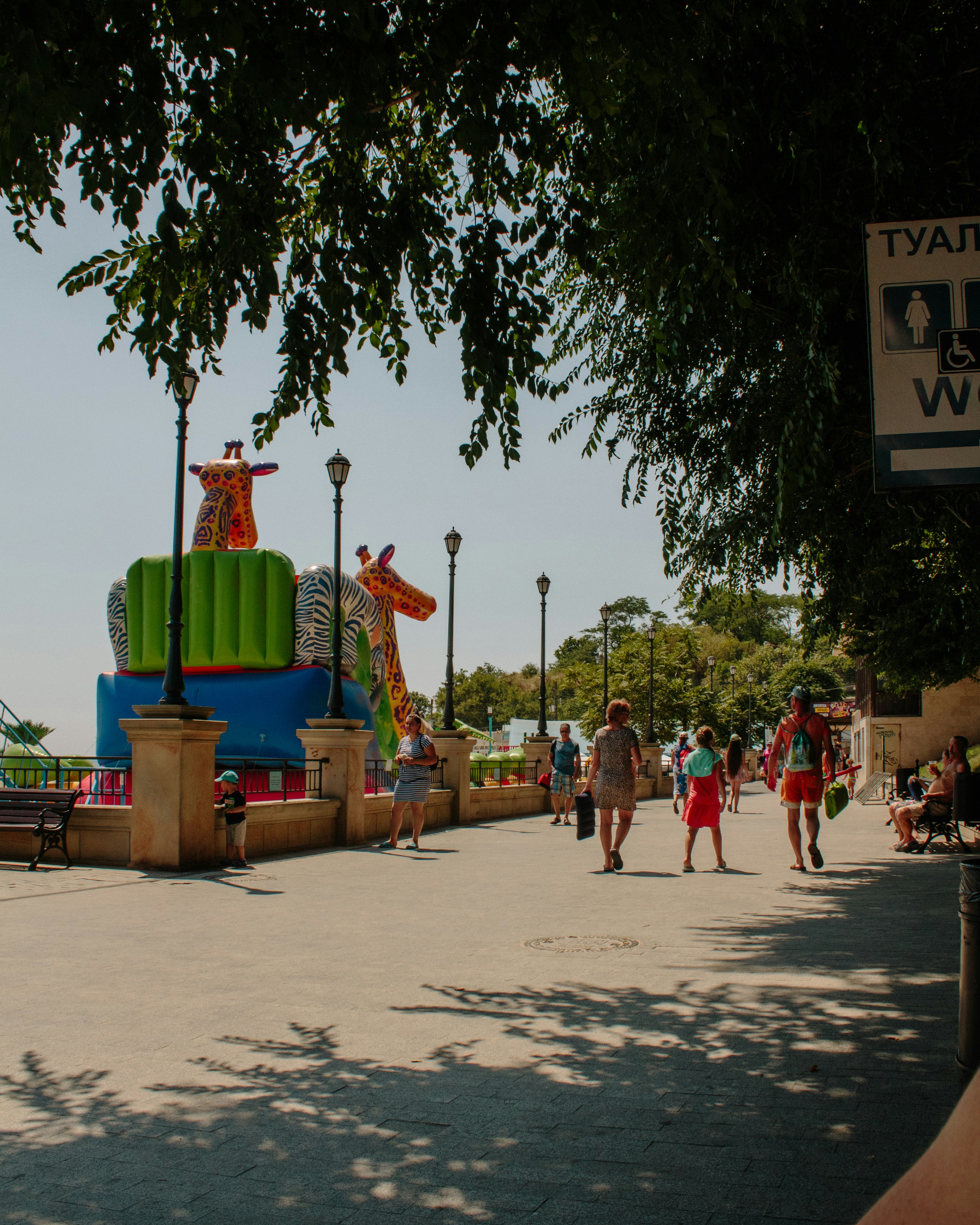 a group of people walking down a street next to a carnival ride