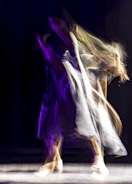 Slow-motion capture of a dancer’s flowing movement against a stark concrete backdrop.