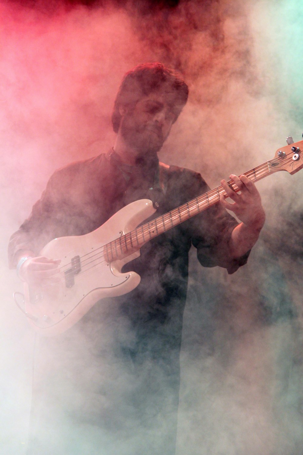 man playing white electric guitar