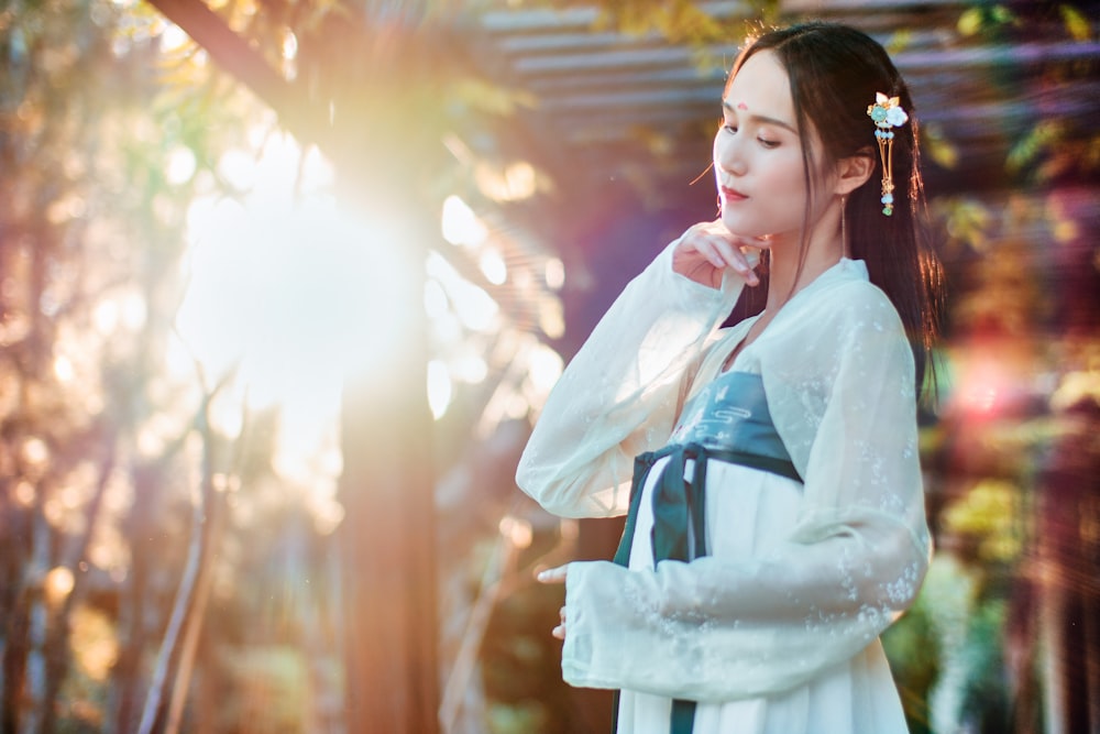 woman standing in white long-sleeved dress during daytime