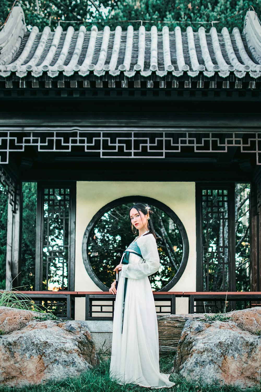 Mujer vestida de hakama blanco frente al templo blanco y negro