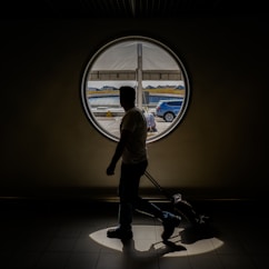 A serene morning scene of a woman closing her suitcase by a sunlit window, ready for her journey.