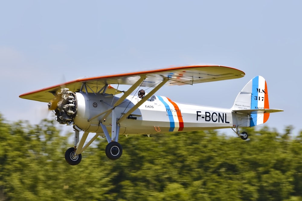 white, orange, and blue plane