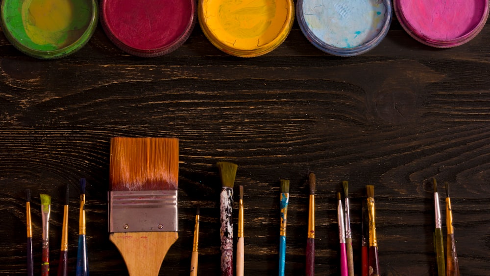 paint brushes on brown surface
