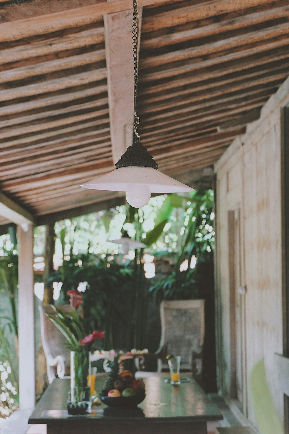 a table and chairs under a wooden roof