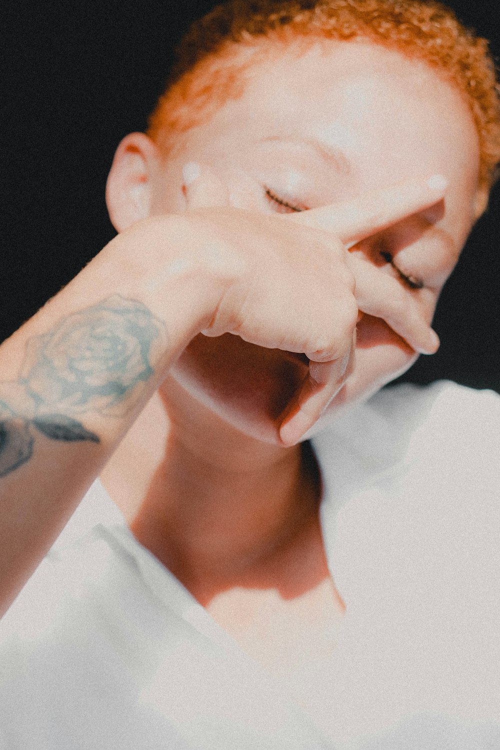 person wearing white shirt holding face photo