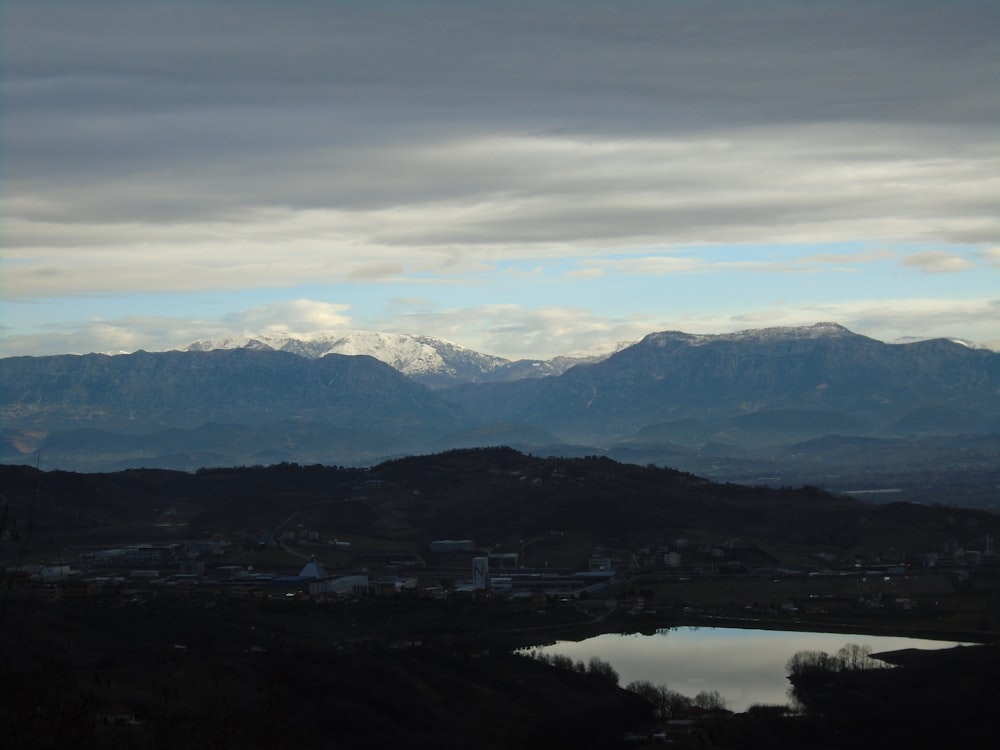 a view of a mountain range with a lake in the foreground