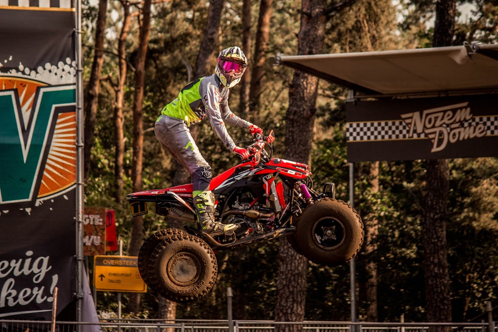 persona que viaja en un ATV rojo de 3 ruedas