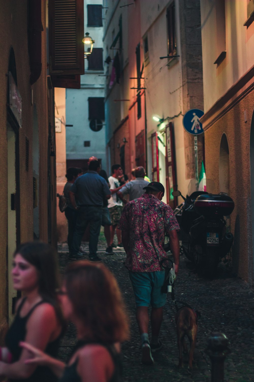a group of people walking down a narrow alley way