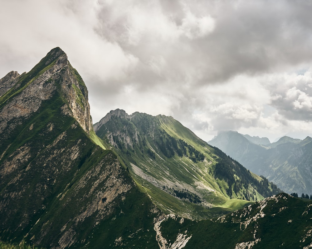 Grüner Berg über dicken weißen Wolken Foto