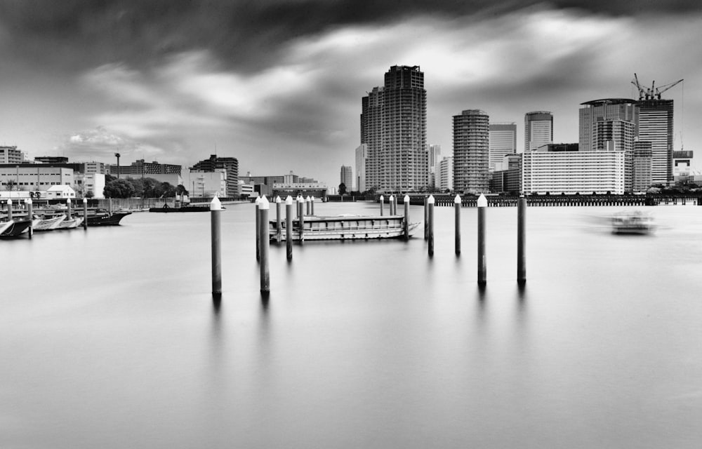 grayscale photo of body of water across city buildings