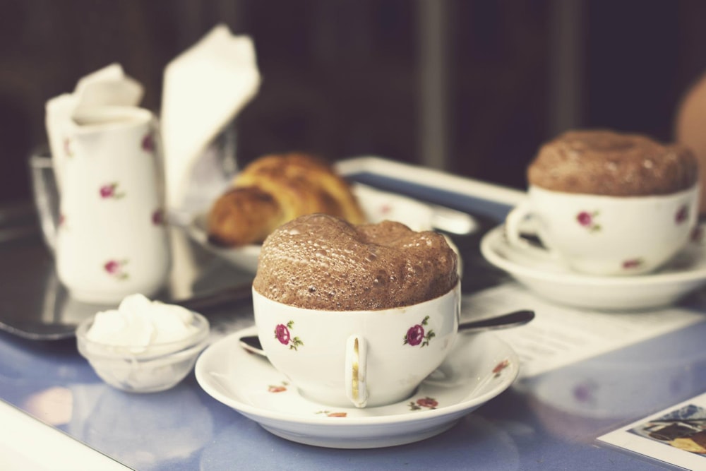 white-and-red ceramic teacups and saucers