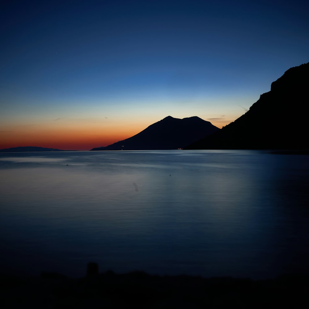 silhouette of mountain beside sea