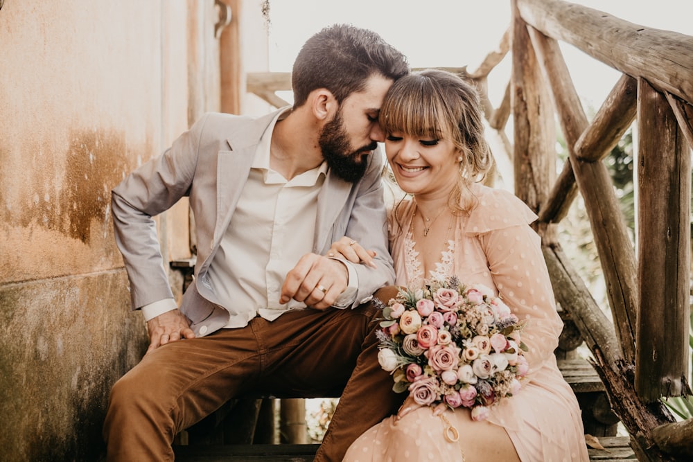 a man and a woman sitting on a wooden bench