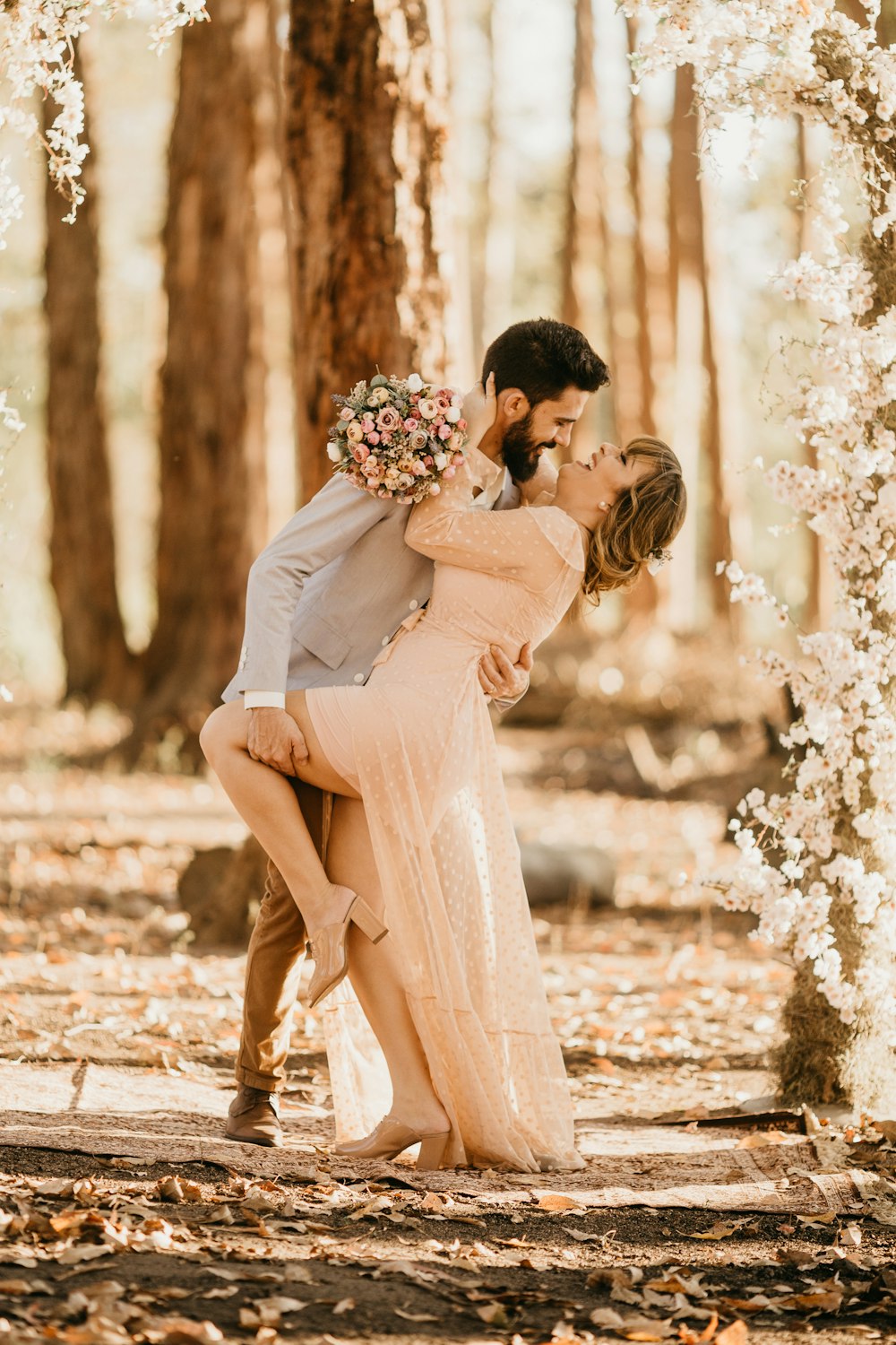 Casal cercado por flores de pétalas cor-de-rosa